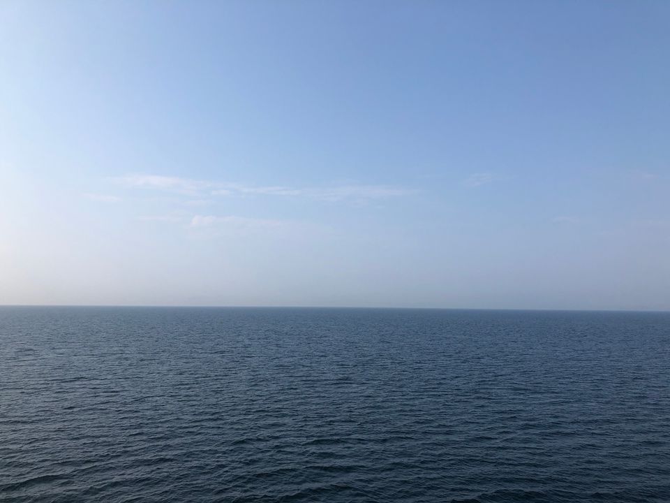 The sky meeting the sea in daylight, light blue against dark blue.